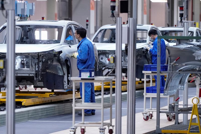 &copy; Reuters. FILE PHOTO: Employees work on assembly line during a construction completion event of SAIC Volkswagen MEB electric vehicle plant in Shanghai, China November 8, 2019. REUTERS/Aly Song