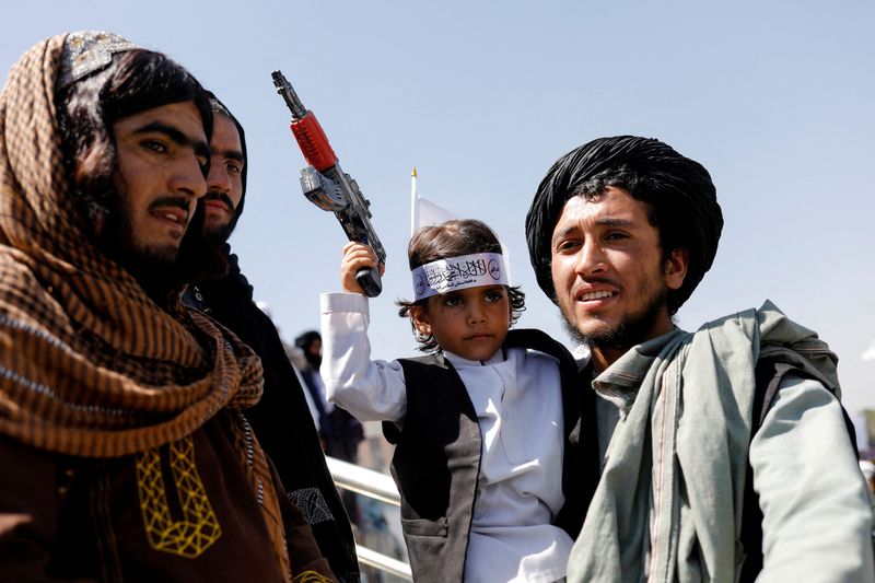&copy; Reuters. FILE PHOTO: A Taliban member holds his son on the first anniversary of the withdrawal of U.S. troops from Afghanistan, on a street in Kabul, Afghanistan, August 31, 2022. REUTERS/Ali Khara/File Photo
