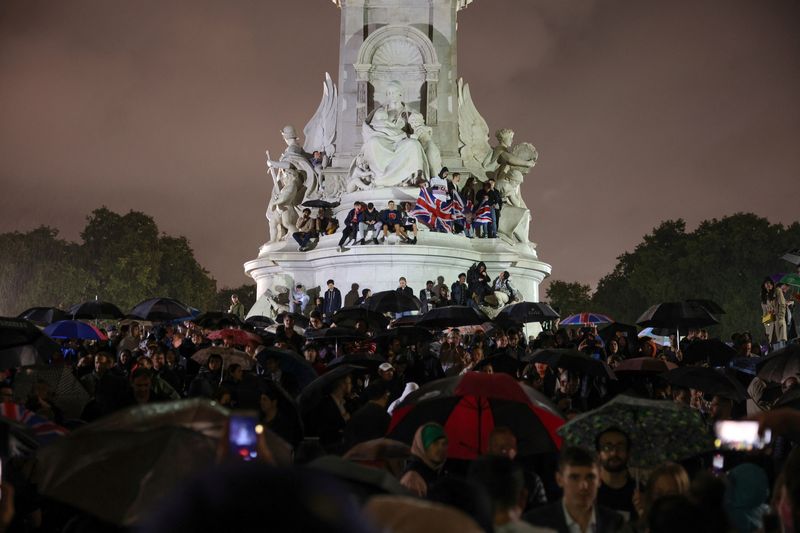 &copy; Reuters. Pessoas reunidas no Memorial Rainha Vitória, em frente ao Palácio de Buckingham após a morte da Rainha Elizabeth 2ª. REUTERS/Kevin Coombs