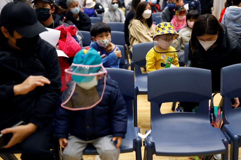 &copy; Reuters.     香港政府は８日、新型コロナウイルスのワクチンパス制度の適用対象を月末から５歳以上の子どもにも拡大すると発表した。資料写真、ワクチン接種会場、２月撮影（２０２２年　ロイ
