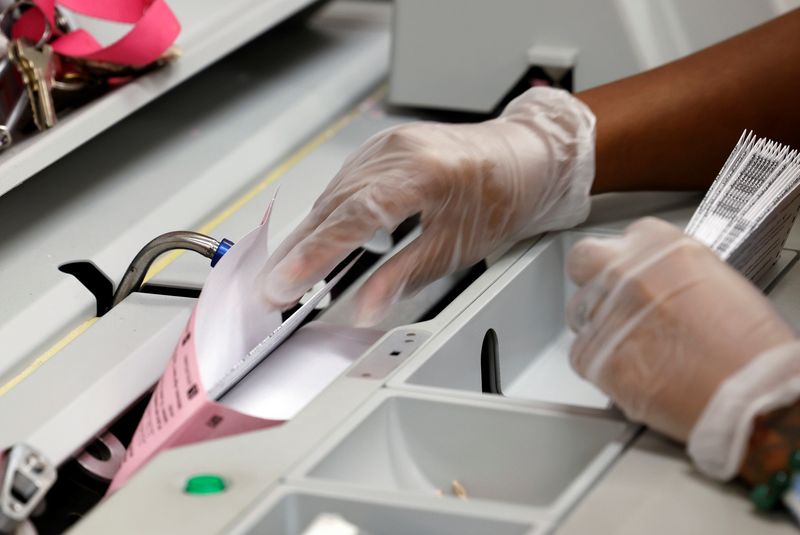 &copy; Reuters. FILE PHOTO: A worker removes mail-in ballots from envelopes at the Sacramento Registrar of Voters in Sacramento, California, U.S., September 14, 2021.  REUTERS/Fred Greaves