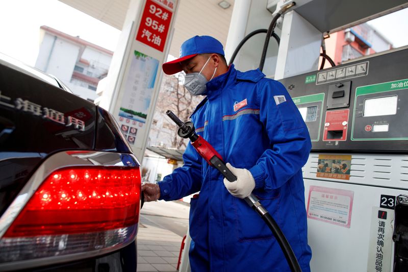 &copy; Reuters. FOTO DE ARQUIVO: Atendente usando máscara reabastece carro em um posto de gasolina Sinopec, em Pequimm China. 28 de fevereiro de 2020. REUTERS/Thomas Peter/File Photo