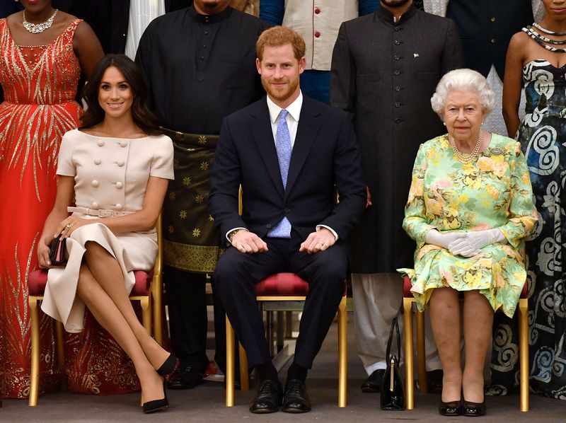 &copy; Reuters. O príncipe Harry e Meghan posam para foto ao lado da Rainha Elizabeth em cerimônia no Palácio de Buckingham em 2018. John Stillwell/Pool via Reuters/Arquivo