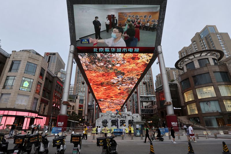 &copy; Reuters. FILE PHOTO: A giant screen shows news footage of Chinese President Xi Jinping visiting Xinjiang Uyghur Autonomous Region, at a shopping centre, in Beijing, China, July 15, 2022. REUTERS/Tingshu Wang/File Photo