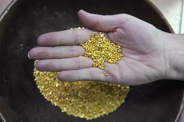 &copy; Reuters. Imagen de archivo de un trabajador mostrando oro granulado en la planta Zlatarna Celje de Celje, Eslovenia. 17 abril 2013. REUTERS/Srdjan Zivulovic
