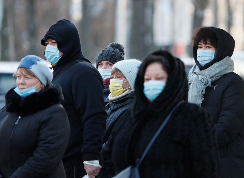 &copy; Reuters. FOTO DE ARCHIVO. Unas personas llevan mascarillas protectoras como medida preventiva contra la propagación de la enfermedad del coronavirus (COVID-19) mientras esperan el autobús en una parada de transporte en un día gélido en Kiev, Ucrania. 22 de dic