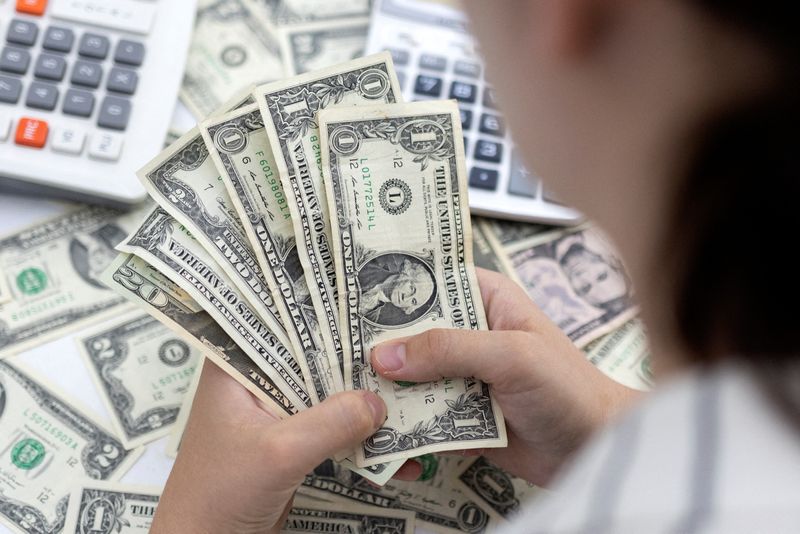 &copy; Reuters. Woman holds U.S. dollar banknotes in this illustration taken May 30, 2022. REUTERS/Dado Ruvic/Illustration