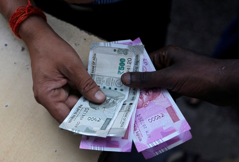 &copy; Reuters. A customer hands Indian currency notes to an attendant at a fuel station in Mumbai, India, August 13, 2018. REUTERS/Francis Mascarenhas/File Photo