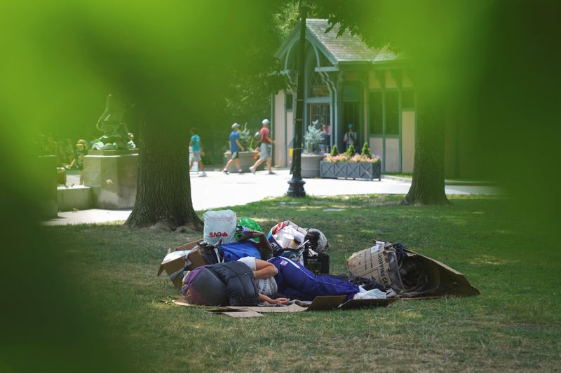 &copy; Reuters. FILE PHOTO: A homeless person lays in the park with their head covered, during a heatwave in Boston, Massachusetts, U.S. July 21, 2022. REUTERS/Allison Dinner