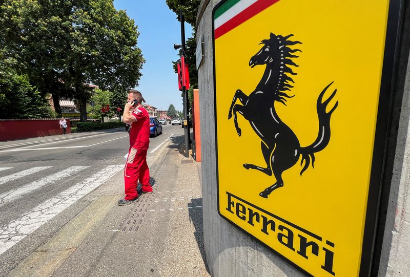 &copy; Reuters. FILE PHOTO: A Ferrari worker speaks on the phone next to the Ferrari logo outside the factory, in Maranello, Italy, June 15, 2022. REUTERS/Flavio Lo Scalzo