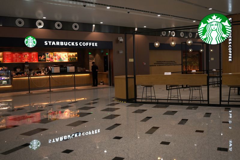 &copy; Reuters. A staff member is seen at Starbucks at the Beijing Daxing International Airport, as the country is hit by an outbreak of the novel coronavirus, in Beijing, China February 20, 2020. REUTERS/Tingshu Wang