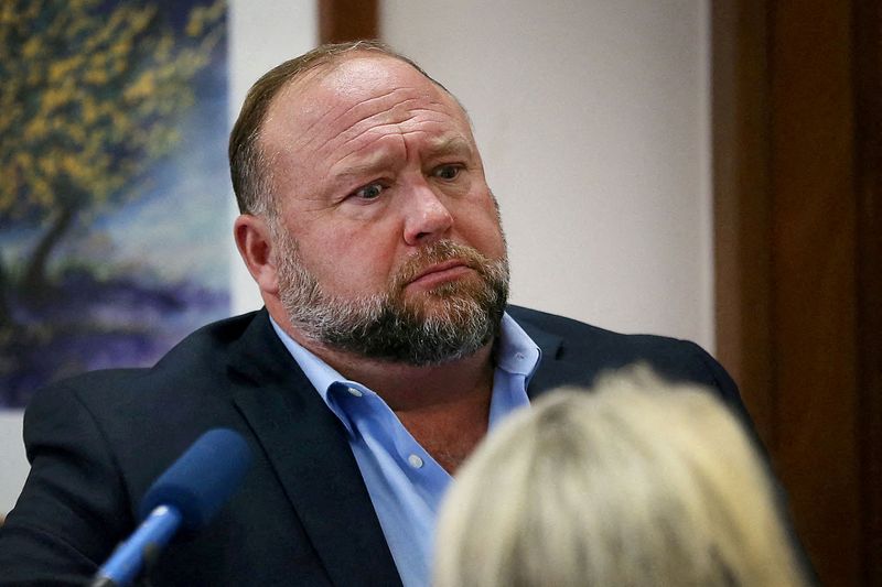 © Reuters. FILE PHOTO: Alex Jones attempts to answer questions about his emails asked by Mark Bankston, lawyer for Neil Heslin and Scarlett Lewis, during trial at the Travis County Courthouse, Austin, Texas, U.S., August 3, 2022.  Briana Sanchez/Pool via REUTERS/File Photo