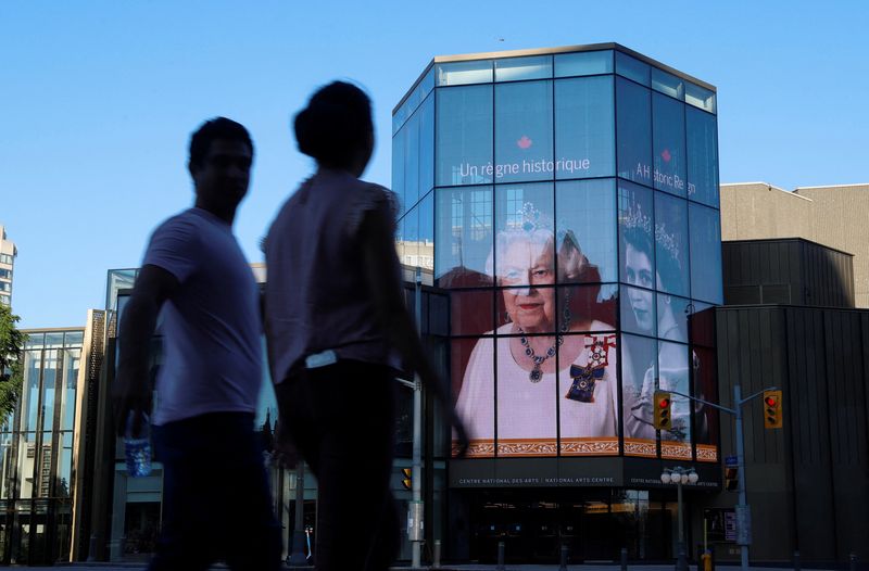 &copy; Reuters. FILE PHOTO:People walk by as a tribute to Queen Elizabeth appears on the National Arts Centre, after Queen Elizabeth's passing, in Ottawa, Ontario, Canada, September 8, 2022.  REUTERS/Patrick Doyle/File Photo