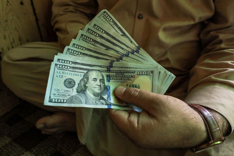 &copy; Reuters. FILE PHOTO: A trader displays U.S. dollar banknotes at a currency exchange booth in Peshawar, Pakistan September 15, 2021. REUTERS/Fayaz Aziz/File Photo