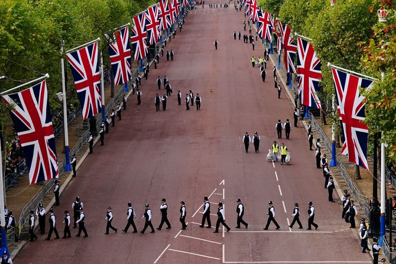 &copy; Reuters. Police officers take up positions as street workers clear away rubbish along The Mall ahead of the ceremonial procession of the coffin of Queen Elizabeth II from Buckingham Palace to Westminster Hall, London. Picture date: Wednesday September 14, 2022. Vi