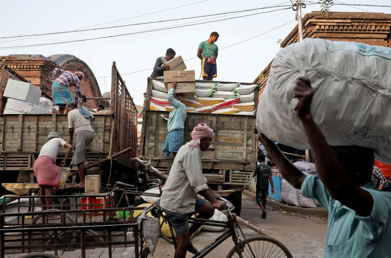 &copy; Reuters. Labourers load consumer goods onto supply trucks at a wholesale market in Kolkata, India, December 14, 2021. REUTERS/Rupak De Chowdhuri