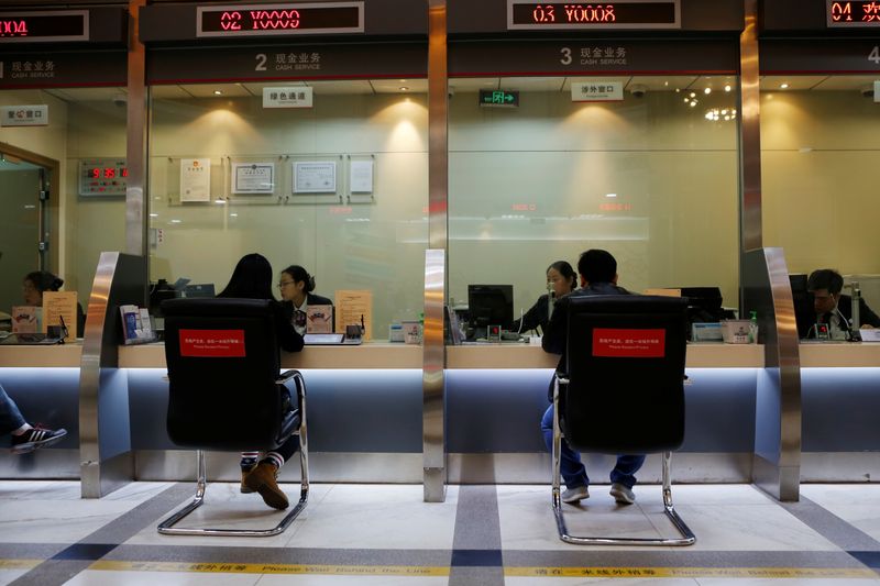 © Reuters. Staff members attend to customers at counters inside a branch of Industrial and Commercial Bank of China (ICBC) in Beijing, China April 1, 2019. Picture taken April 1, 2019. REUTERS/Florence Lo