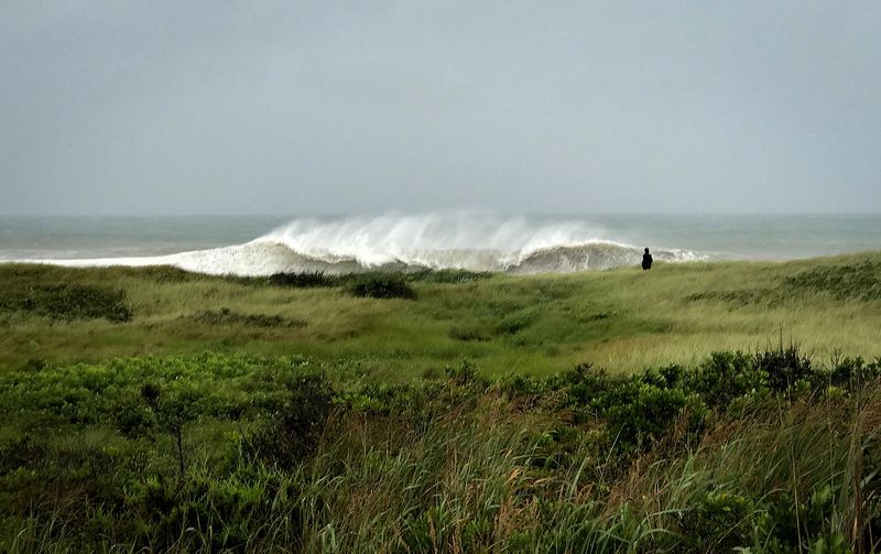 &copy; Reuters. FILE PHOTO: A person walks in the sand Dunes as heavy surf rolls onto the south shore of Martha's Vineyard island in West Tisbury, Massachusetts, U.S., August 22, 2021. John Segar via REUTERS/File Photo