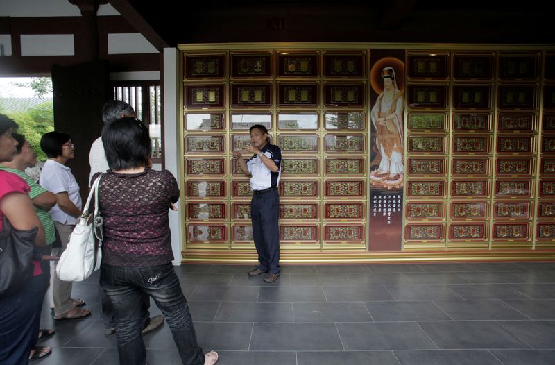 &copy; Reuters. FILE PHOTO: A salesperson talks to potential customers at the columbarium section of Nirvana Memorial Park in Shah Alam outside Kuala Lumpur on September 5, 2010. REUTERS/Bazuki Muhammad/File Photo