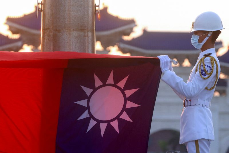 © Reuters. FILE PHOTO: Honour guards lower the Taiwan flag during sunset hours at Liberty Square in Taipei, Taiwan, July 28, 2022. REUTERS/Ann Wang/File Photo