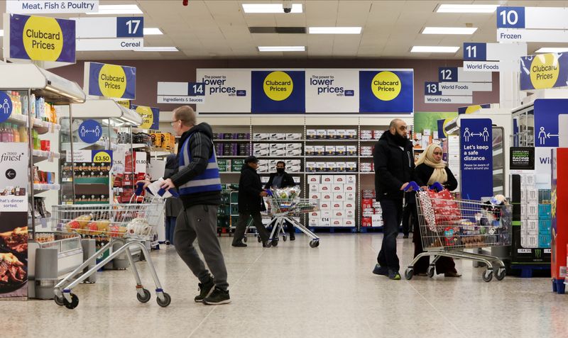 &copy; Reuters. FILE PHOTO: Shoppers walk next to the clubcard price branding inside a branch of a Tesco Extra Supermarket in London, Britain, February 10, 2022. Picture taken February 10, 2022. REUTERS/Paul Childs/File Photo