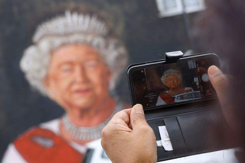 &copy; Reuters. شخص يلتقط صورة للوحة جدارية للملكة إليزابيث بعد وفاتها في لندن يوم الخميس. تصوير:  كاي فافنباخ - رويترز.