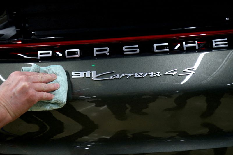 &copy; Reuters. FOTO DE ARCHIVO: Un empleado del fabricante de automóviles alemán Porsche arregla una etiqueta de Porsche 911 Carrera 4S en la fábrica de Porsche en Stuttgart-Zuffenhausen, Alemania, el 19 de febrero de 2019. REUTERS/Ralph Orlowski