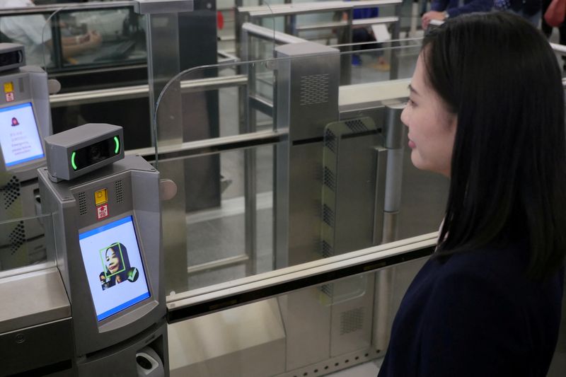 &copy; Reuters. FILE PHOTO: A "smart departure" self-service machine scans a woman's face to authenticate her identity using face recognition technology, during a demonstration by the Immigration Department at Hong Kong Airport in Hong Kong, China October 9, 2017.   REUT