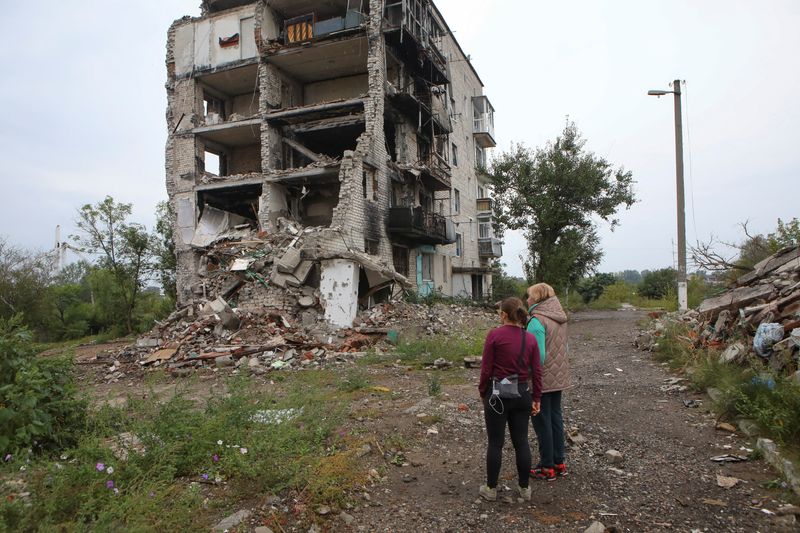 &copy; Reuters. Mulheres olham para prédio residencial destruído por ataque militar na cidade de Izium, na Ucrânia. REUTERS/Vyacheslav Madiyevskyy