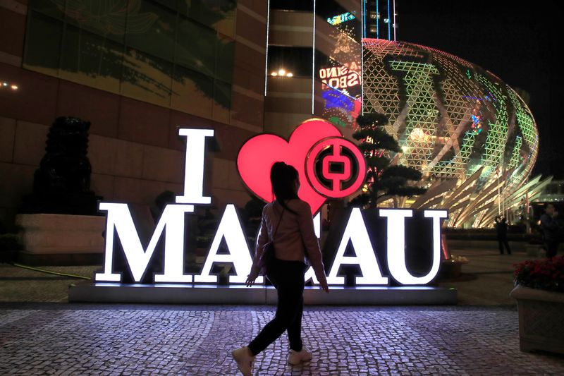 &copy; Reuters. A woman walks past a Bank of China branch next to the Grand Lisboa hotel and casino (R) in Macau, China December 21, 2019. REUTERS/Jason Lee