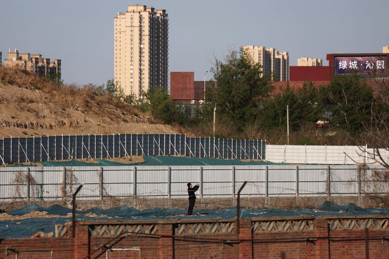 &copy; Reuters.  A man walks at a construction site near residential buildings in Beijing, China April 14, 2022. Picture taken April 14, 2022. REUTERS/Tingshu Wang