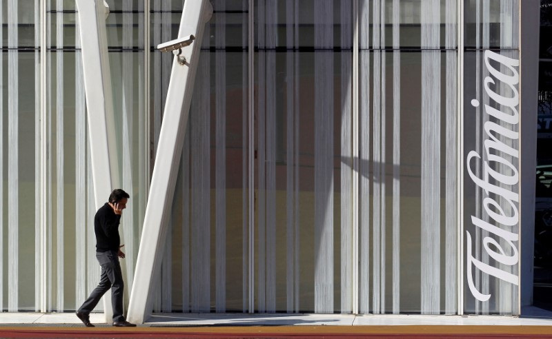 &copy; Reuters. FOTO DE ARCHIVO. Un hombre habla por un móvil junto a la torre de Telefónica en Barcelona, Cataluña, España. 30 de enero de 2013. REUTERS/Albert Gea