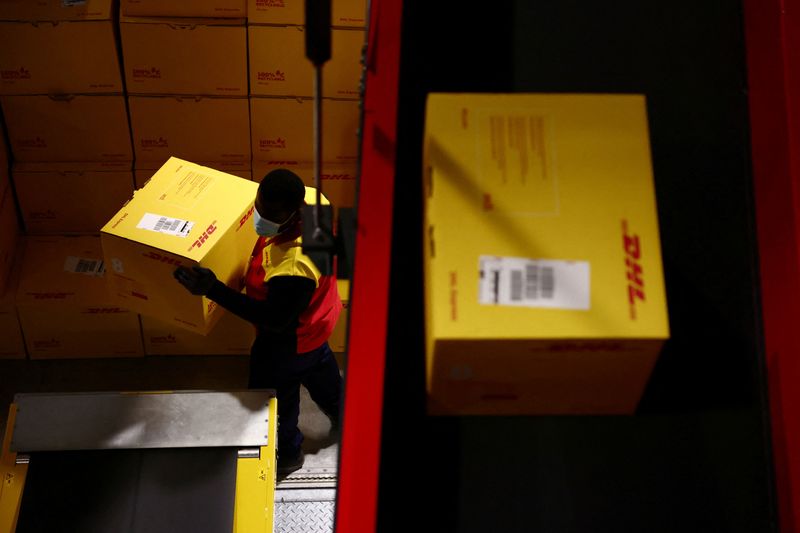 &copy; Reuters. FILE PHOTO: An employee carries a delivery package inside the new DHL Express hub of German postal and logistics group Deutsche Post DHL at the Roissy Charles de Gaulle airport in Tremblay-en-France near Paris, France, October 5, 2021. REUTERS/Sarah Meyss