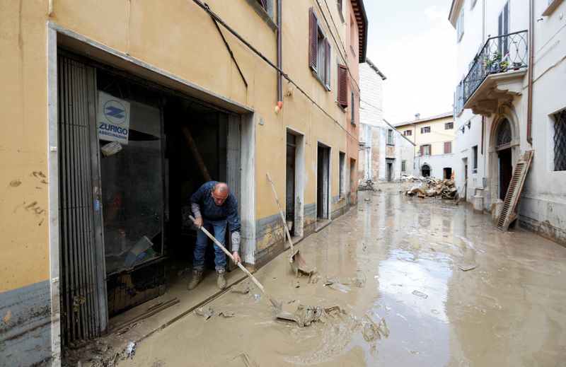 &copy; Reuters. شخص يحاول إزالة أثار الأمطار الغزيرة والفيضانات في منطقة ماركي بوسط إيطاليا يوم الجمعة. تصوير: يارا ناردي - رويترز.