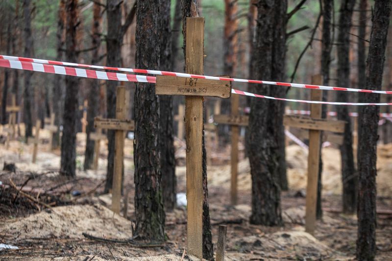 &copy; Reuters. Cartelli sopra a fosse comuni in un cimitero improvvisato a Izium, in Ucraina. REUTERS/Oleksandr Khomenko