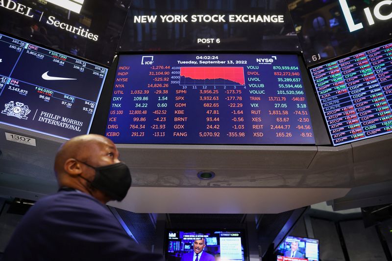 © Reuters. A trader stands beneath a screen on the trading floor displaying the Dow Jones Industrial Average at the New York Stock Exchange (NYSE) in Manhattan, New York City, U.S., September 13, 2022. REUTERS/Andrew Kelly