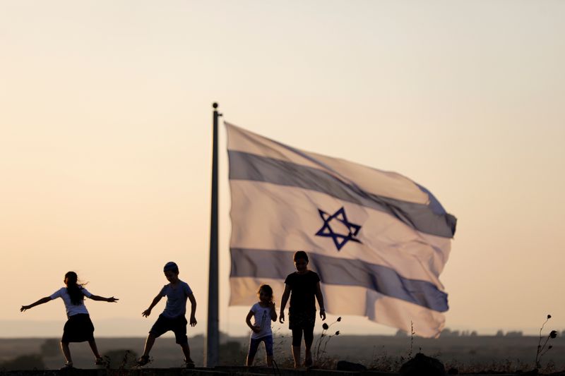 &copy; Reuters. FILE PHOTO: Israeli kids play next to an Israeli flag next to the Israeli Syrian border at the Israeli-occupied Golan Heights, Israel July 23, 2018. REUTERS/Ronen Zvulun/File Photo