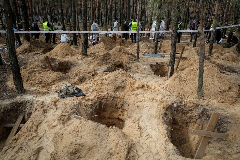 Ukrainians search grave site for relatives after Russians driven out