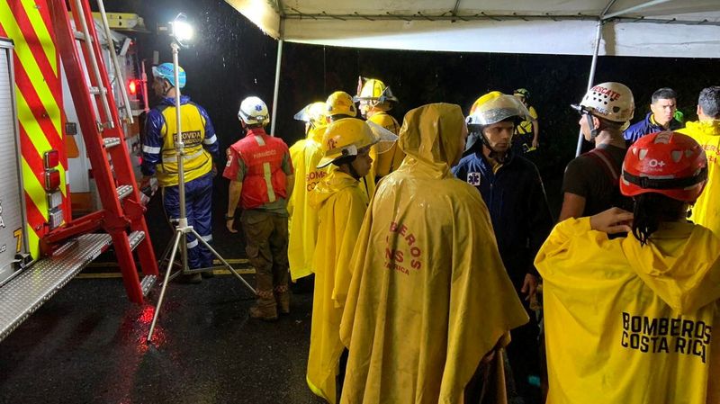 © Reuters. رجال الإطفاء في موقع حادث تحطم حافلة بسبب هطول أمطار غزيرة في كوستاريكا يوم السبت. صورة حصلت عليها رويترز من وسائل التواصل الاجتماعي.