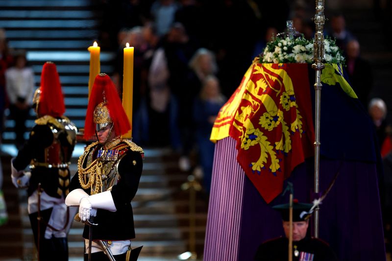 &copy; Reuters. أفراد من سلاح الفرسان والعائلة الملكة يحرسون يحرسون تابوت الملكة إليزابيث الثانية المغطى بالعلم في قاعة وستمنستر في لندن يوم الأحد. صورة لر