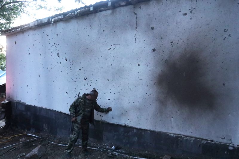 &copy; Reuters. رجل يقف أمام بناية في أرمينيا لحقت بها أضرار جراء القصف خلال الاشتباكات الحدودية التي وقعت مؤخرا مع أذربيجان في صورة التقطت يوم 15 سبتمبر أيل