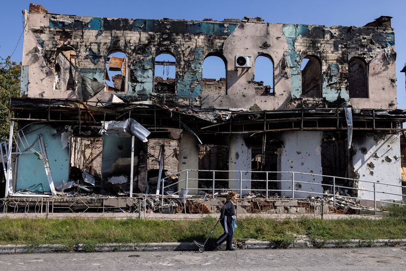 © Reuters. A woman walks past a destroyed building, as Russia's attack on Ukraine continues, in the town of Izium, recently liberated by Ukrainian Armed Forces, in Kharkiv region, Ukraine September 18, 2022. REUTERS/Umit Bektas