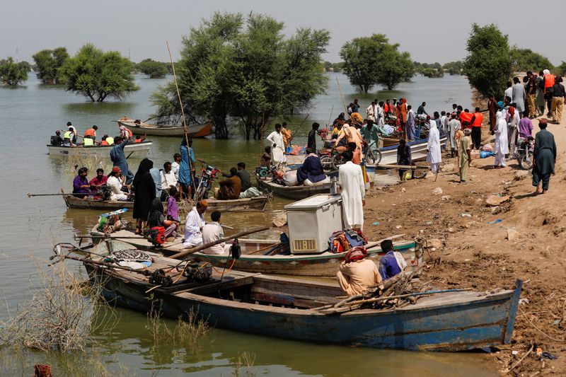 © Reuters. FILE PHOTO: Flood victims use boats to reach their villages, following rains and floods during the monsoon season in Sehwan, Pakistan, September 16, 2022. REUTERS/Akhtar Soomro