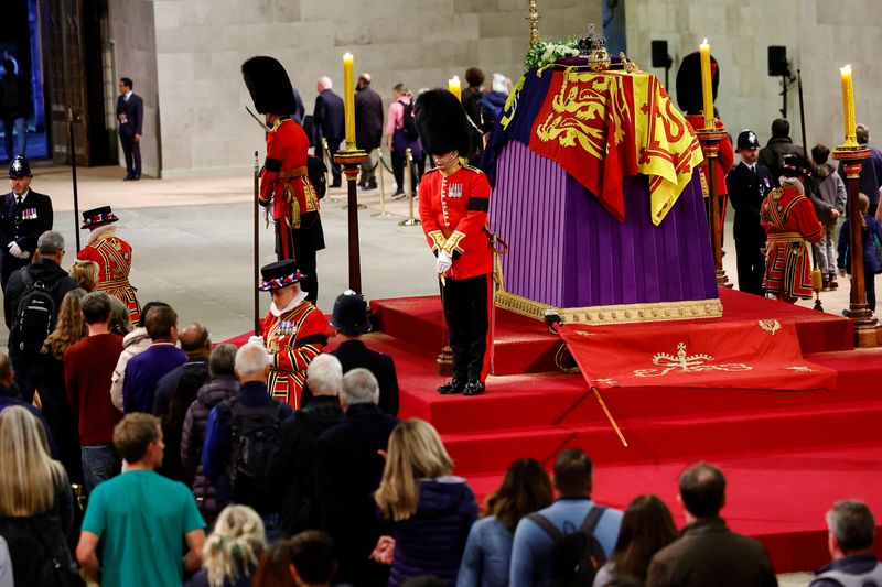 &copy; Reuters. أفراد من الحرس الملكي يقفون بجانب نعش الملكة إليزابيث الثانية بينما يلقي بعض العامة نظرة الوداع على جثمانها بقاعة وستمنستر التاريخية بلندن