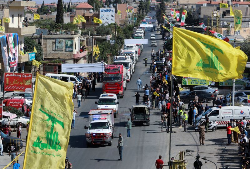 © Reuters. أعلام حزب الله ترفرف لدى وصول قافلة شاحنات تحمل وقودا إيرانيا إلى قرية العين شمال شرق لبنان بصورة من أرشيف رويترز.