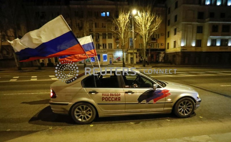 &copy; Reuters. Un'automobile con due bandiere russe in mostra sfila a Donetsk, nell'Ucraina orientale. 21 febbraio 2022 REUTERS/Alexander Ermochenko