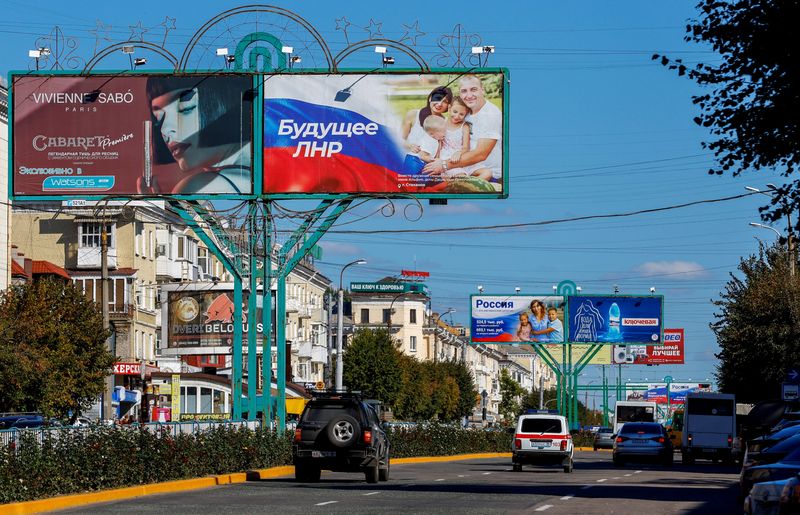 © Reuters. Vehicles drive past advertising boards, including panels displaying pro-Russian slogans, in a street in the course of Russia-Ukraine conflict in Luhansk, Ukraine September 20, 2022. REUTERS/Alexander Ermochenko