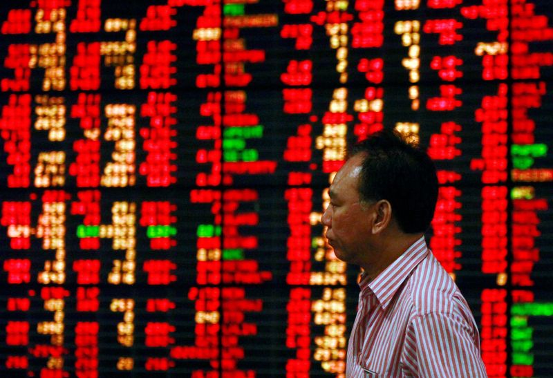 © Reuters. Homem passa pela frente de painel eletrônico mostrando cotações do mercado financeiro. 9/8/2011. REUTERS/Chaiwat Subprasom