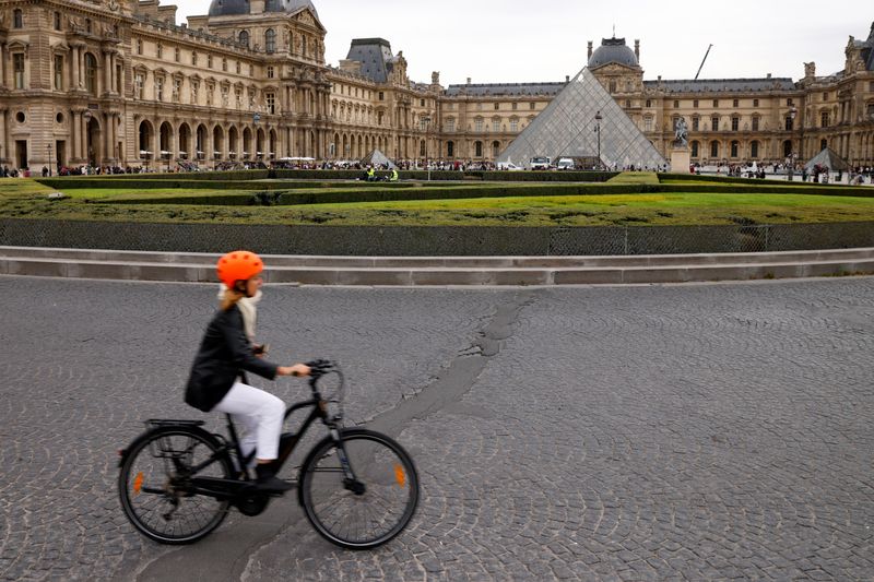 &copy; Reuters. A woman rides her bicycle near the glass Pyramid of the Louvre museum in Paris, France, September 20, 2022. REUTERS/Rali Benallou  NO RESALES. NO ARCHIVES