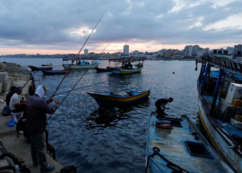 &copy; Reuters. صيادون فلسطينيون يفرغون السمك الذين اصطادوه في ميناء غزة يوم الثلاثاء. تصوير: محمد سالم - رويترز.
